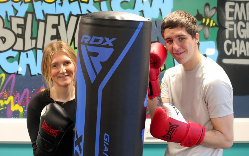 Chelsea and Adam at a boxing session, next to a punchbag