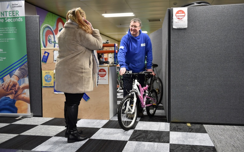 A customer buying a bike in the Active Cycles shop from a member of staff.